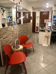 a waiting room with two red chairs and a table at Guest House Brianza Room in Milan