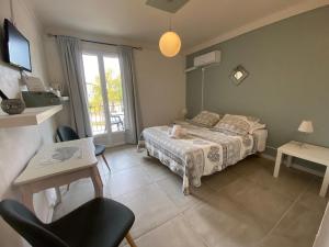 a bedroom with a bed and a table and a window at Hotel Carina in Apt