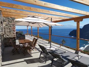 a patio with a table and chairs and an umbrella at Casa Sol in Hermigua