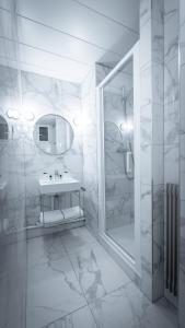 une salle de bain blanche avec un lavabo et une douche dans l'établissement Hôtel du Parc Montparnasse, à Paris