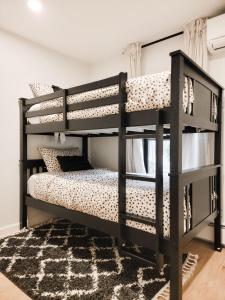 a bedroom with two bunk beds and a rug at Black Pearl Unit 2 - Lake Placid, Mirror Lake in Lake Placid