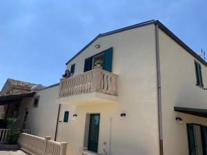 a white building with a balcony on top of it at Agriturismoeloropizzuta in Noto Marina