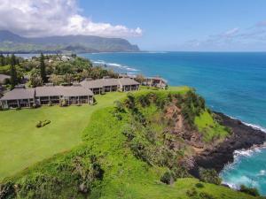 an aerial view of a house on a hill next to the ocean at Pali Ke Kua #241 in Princeville
