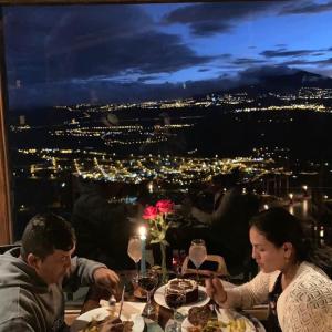 Um homem e uma mulher sentados à mesa com comida. em La Montaña Restaurante Mirador em Patate