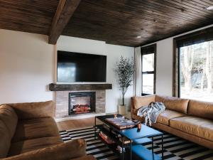 a living room with a couch and a fireplace at Alpine Lodge - Lake Placid, Mirror Lake in Lake Placid