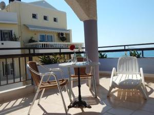 een patio met 2 stoelen en een tafel op een balkon bij Posidonio Hotel in Chania