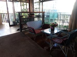 a room with a table and chairs on a balcony at BEN & LEK GUESTHOUSE in Pattaya South