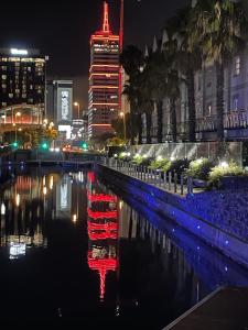 uma cidade iluminada à noite com um reflexo na água em HOTEL SKY Cape Town em Cidade do Cabo
