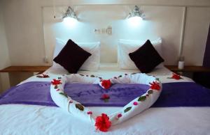 a bed with a heart made out of flowers on it at Kilimani Kwetu Beach Hotel in Bwejuu