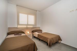 - 2 lits dans une chambre avec fenêtre dans l'établissement Apartment Aguacate, à San Juan de los Terreros