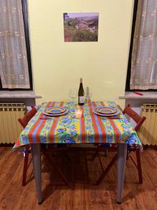 una mesa con una botella de vino y dos copas en Un tocco provenzale a Savigliano, en Savigliano