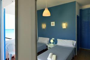 a blue room with two beds and a mirror at El Bahía Algeciras in Algeciras +43 photos