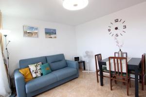 a living room with a blue couch and a table at Apartment with balcony close to the beach in Lloret de Mar