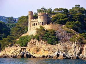 a castle on an island in the water at Apartment with balcony close to the beach in Lloret de Mar