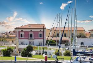 a marina with boats docked in front of a pink house at Villino Ermione in Marina di Pisa