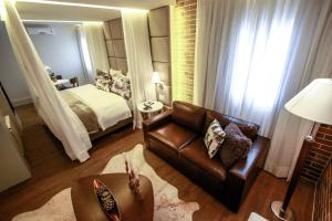 - un salon avec un canapé et un lit dans l'établissement Hotel Cercano, à Gramado