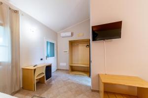 a room with a desk and a tv on a wall at Agriturismo Is Cortillaris in Càbras