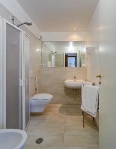 a bathroom with two sinks and a toilet and a shower at Villino Ermione in Marina di Pisa