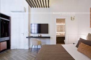 - une chambre avec un lit et un bureau avec une télévision dans l'établissement Umberto34-Luxury Home, à Naples