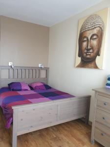 ein Schlafzimmer mit einem Bett mit einem Kopf an der Wand in der Unterkunft Villers sur Mer - Cocon familial, détente, évasion, vue sur mer in Villers-sur-Mer