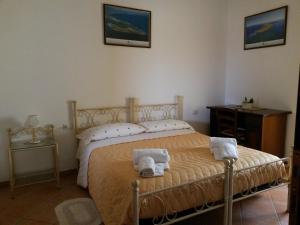 a bedroom with a bed with two towels on it at Affittacamere Le Statue Del Sinis in Càbras