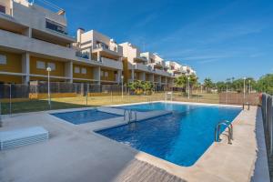 a swimming pool in front of a apartment building at El Bosque in Orihuela Costa