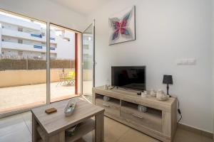 a living room with a flat screen tv and a table at El Bosque in Orihuela Costa
