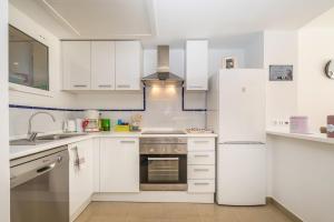 a white kitchen with white cabinets and a stove at El Bosque in Orihuela Costa