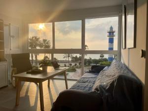 a bedroom with a bed and a table and a lighthouse at El Faro de Torre del Mar in Torre del Mar