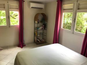 A bed or beds in a room at APPARTEMENT COLIBRI , Les Anses d 'Arlet