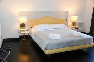une chambre avec un grand lit avec deux lampes dans l'établissement Le Suite Guarinelli B&B, à Gaète