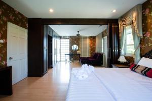 a bedroom with a large bed and a living room at Private Pool Villa Beach WashMachine @Rayong會說中文 in Ban Nong Si Tong