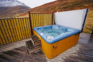 a hot tub sitting on top of a deck at Langahlid Cottages & Hot Tubs in Seyðisfjörður