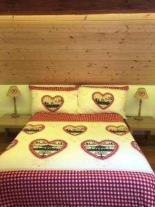 a bed with heart pillows on top of it at Chalet Schwendli in Schwarzsee