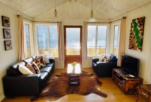 a living room with a couch and a coffee table at Langahlid Cottages & Hot Tubs in Seyðisfjörður