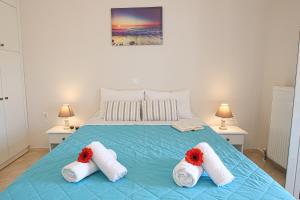 ein Schlafzimmer mit einem Bett mit roten Blumen darauf in der Unterkunft Teta's house sea view in Marathias