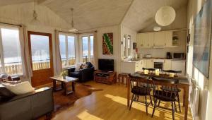 a living room with a couch and a table and a kitchen at Langahlid Cottages & Hot Tubs in Seyðisfjörður