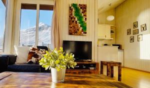 a living room with a table with a vase of flowers at Langahlid Cottages & Hot Tubs in Seyðisfjörður