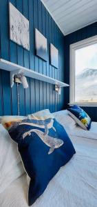 a bedroom with a whale pillow on a bed at Langahlid Cottages & Hot Tubs in Seyðisfjörður