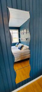 a bedroom with a bed in a blue wall at Langahlid Cottages & Hot Tubs in Seyðisfjörður