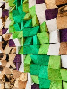 a wall filled with different colored wood pieces at Langahlid Cottages & Hot Tubs in Seyðisfjörður