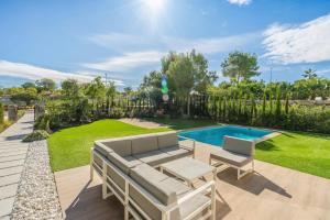 a backyard with a swimming pool and a patio with two chairs at Colinas in Orihuela Costa
