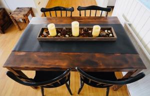 a wooden table with candles and rocks on it at Langahlid Cottages & Hot Tubs in Seyðisfjörður