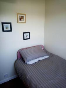 3-Bed House 5 minute walk from Inverness Centre في إينفيرنيس: سرير في غرفة نوم مع صورتين على الحائط