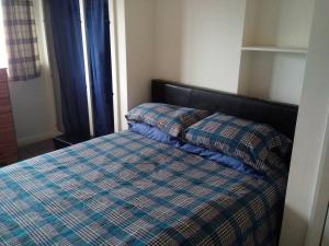 3-Bed House 5 minute walk from Inverness Centre في إينفيرنيس: غرفة نوم مع سرير مع لحاف مرتب