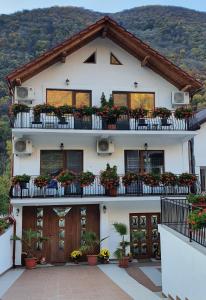ein weißes Haus mit Blumenkästen auf den Balkonen in der Unterkunft Casa Mimi in Băile Herculane
