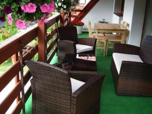 a patio with wicker chairs and a table with flowers at Pensjonat Relax in Mikołajki