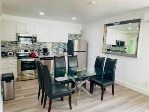 a kitchen with a glass table and green chairs at Casa Wynwood 4BR 2BTH in Miami
