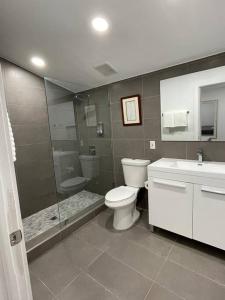 y baño con aseo, ducha y lavamanos. en Casa Wynwood 4BR 2BTH, en Miami