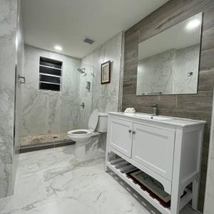 a bathroom with a toilet and a sink and a shower at Casa Wynwood 4BR 2BTH in Miami